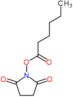 1-(hexanoyloxy)pyrrolidine-2,5-dione